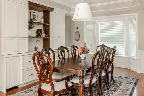 Dining room built-in cabinet with open shelving beside a candle-lit wood table