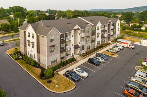 Aerial view of an apartment building with balconies, parking and a moving truck outside