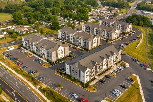 Aerial shot of a suburban apartment community with connected buildings and paved parking areas