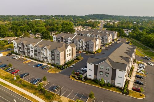Aerial view of two apartment buildings with parking lots and freshly mulched landscaping beds