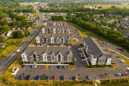 Aerial view of apartment buildings near open farmland with a grain silo on the horizon