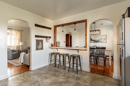Wood-framed breakfast bar pass-through connecting the kitchen to open living and dining rooms