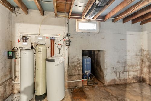 Utility room with paired water softener tanks and a blue pressure tank