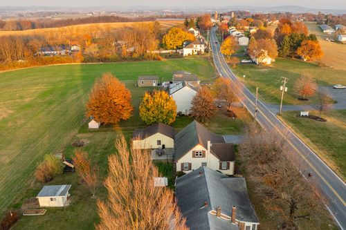 Aerial view of a small-town neighborhood glowing with fall foliage at sunset