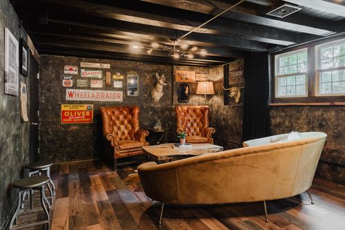 Lounge seating with leather wingbacks, a curved sofa and vintage signage