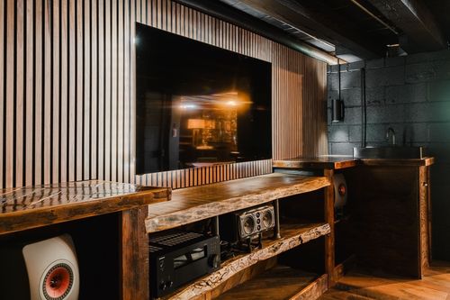 Corner wet bar with a live-edge wood counter, stainless sink and slatted wood wall