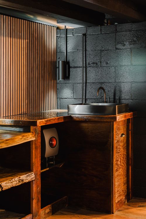 Industrial wet bar corner with a stainless vessel sink and wood counter