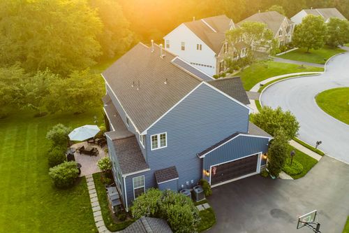 Aerial view of a blue colonial in a cul-de-sac neighborhood with a basketball hoop