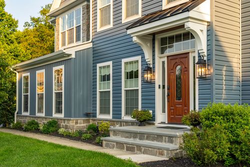 Front porch corner with a black standing-seam roof and stone foundation