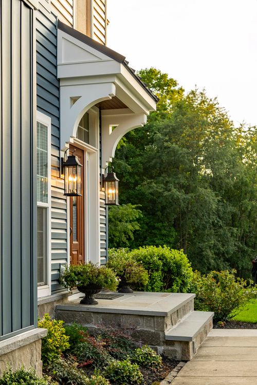 Front porch detail with a white bracketed overhang and stone steps