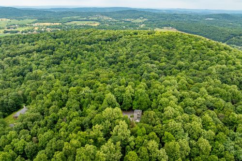 Aerial view of a secluded modern home surrounded by miles of rolling forest
