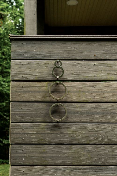 Close-up of horizontal composite wood siding with circular metal accent rings