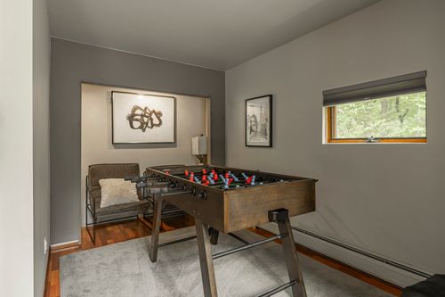 Game room with a foosball table, leather chair and abstract artwork