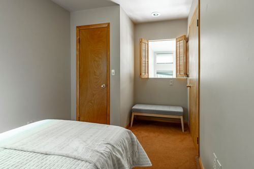 Bedroom nook with plantation shutters, a small bench seat and wood-trimmed doors