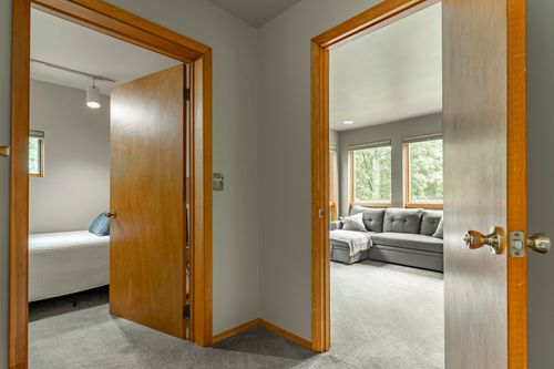 Two open bedroom doors, one leading to a bunk room and the other to a window-filled loft