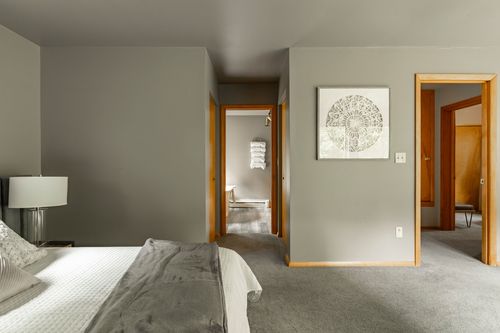 Primary bedroom hallway with framed art and doors opening to the bath and closet