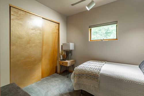 Bedroom with a wood-toned sliding closet door and a small nightstand with a table lamp