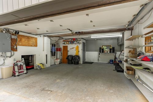 Garage with built-in storage shelving and a workbench along the wall