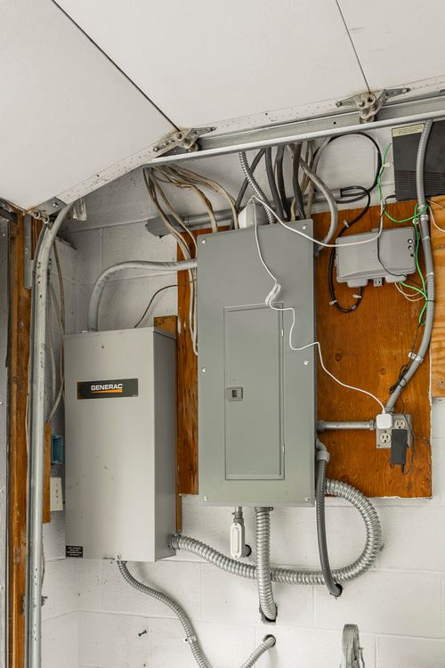 Electrical panel and backup generator mounted on a garage wall