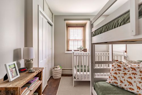 Nursery with white crib, wood console table and built-in bunk bed
