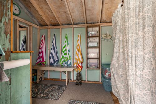 Pool house changing room with colorful striped beach towels hung on hooks
