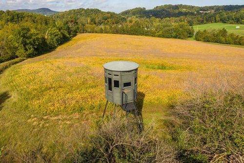 Aerial view of a wooden deer stand overlooking a golden hillside field