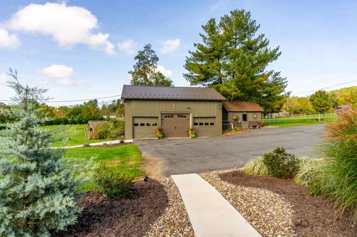 Detached garage with three bays and a stone walkway leading to the entrance