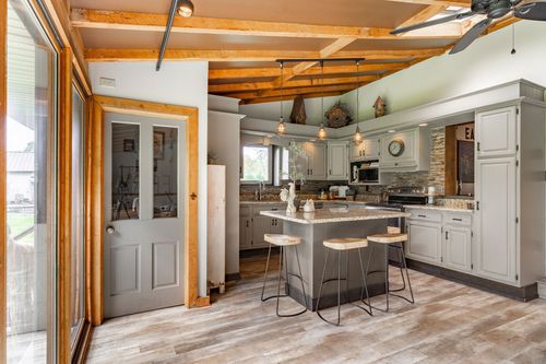 Kitchen and dining area with wood beams, pendant lights and island seating