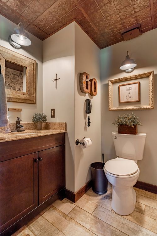 Powder room with pressed-tin ceiling, dark wood vanity and cross wall accent