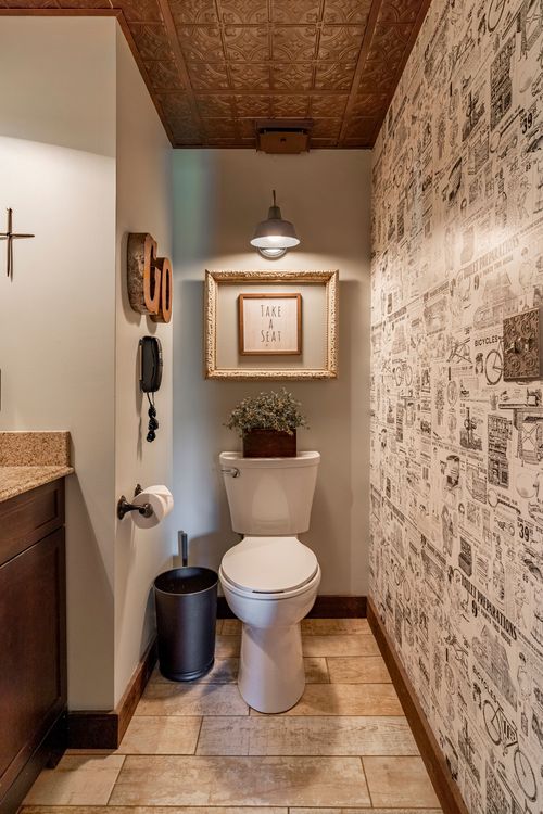 Small bathroom with pressed-tin ceiling and vintage newspaper-print wallpaper