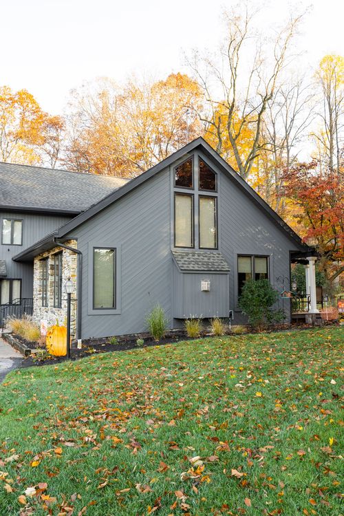 Gray gabled home exterior with vaulted windows and pumpkin porch decor in autumn