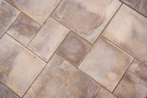 Close-up texture of tan and gray stone paver patio tiles