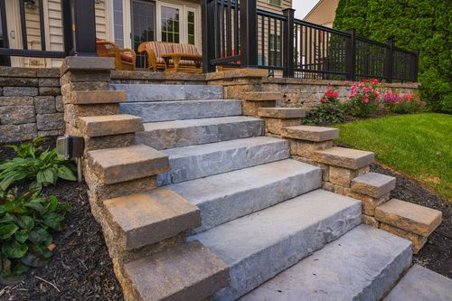 Close-up of a stacked stone staircase with wicker deck chairs above