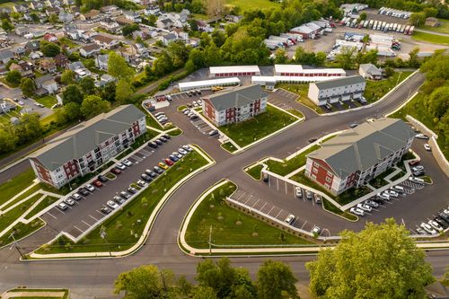 Aerial view of apartment buildings with landscaped courtyards beside a residential street