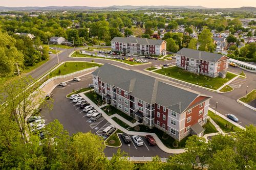 Aerial view of apartment buildings with white fencing and curved access roads