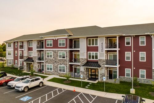 Aerial view of a red-brick apartment building with stone accents and covered entries