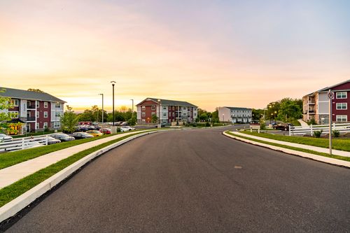 Apartment complex street view with buildings and parking lots at sunset