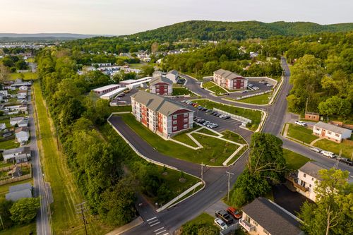 Aerial view of an apartment complex overlooking a residential neighborhood at sunset