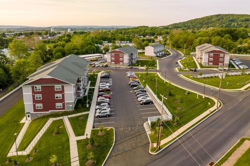 Aerial view of apartment buildings and parking lots overlooking a small town at sunset
