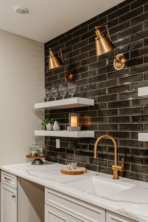 Wet bar corner with a lit candle, marble counter and black tile backsplash