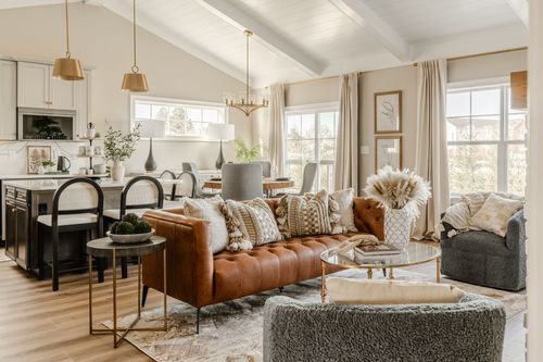 Bright living room with a white brick fireplace, leather sofa and vaulted shiplap ceiling