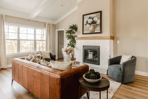 Kitchen island with brass pendant lighting, marble backsplash and upholstered bar stools