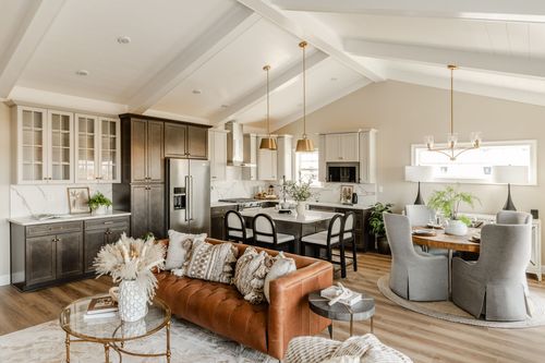 Kitchen with vaulted shiplap ceiling, mixed dark and white cabinetry and gold pendant lighting