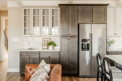 Kitchen island with white quartz counters and black caned dining chairs