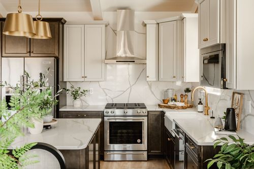 Kitchen with a built-in microwave, marble backsplash and farmhouse sink beside a dishwasher