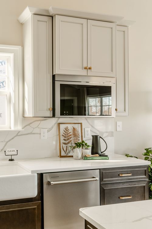 Bedroom nightstand styled with a white lamp, a vase and a tray holding a teapot