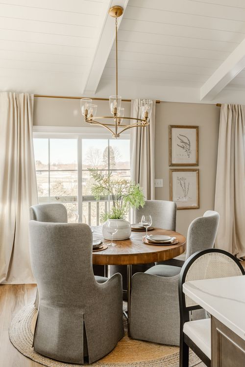 Bedroom with a round mirror above a dresser and neutral bedding
