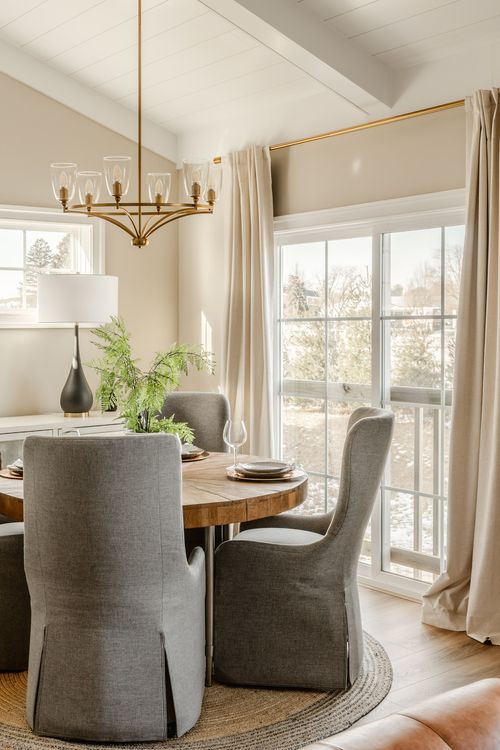 Bedroom corner with a dresser, upholstered chair and softly made bed