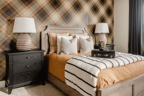 Bedroom with plaid accent wallpaper, a wood headboard and matching bedside lamps