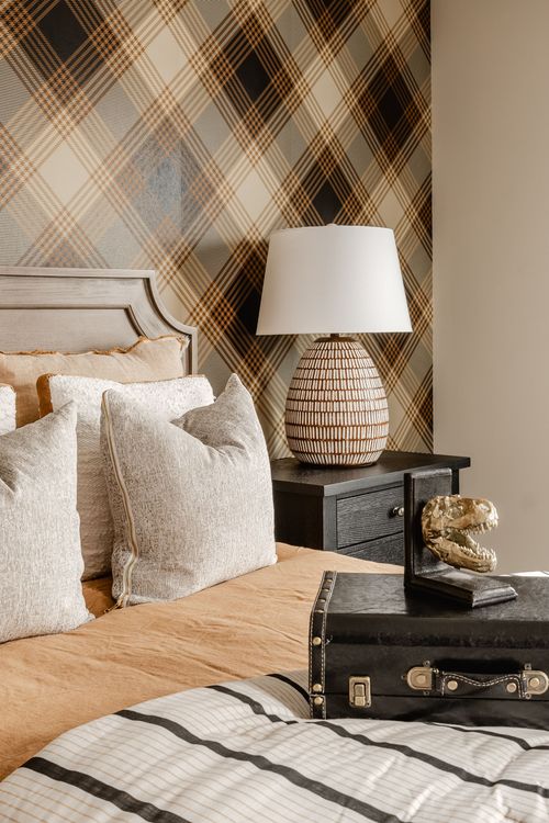 Close-up of a plaid wallpaper accent wall with a black nightstand styled with decor